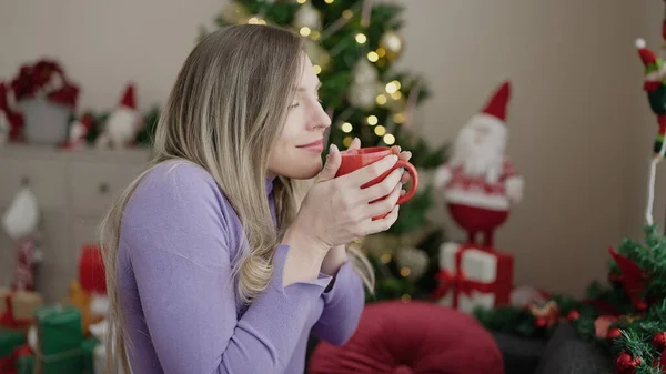 Genç Sarışın Kadın Evdeki Noel Ağacının Yanındaki Koltukta Kahve Kokusu — Stok fotoğraf