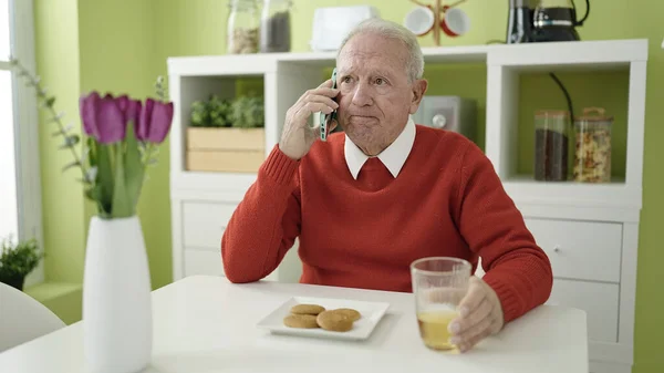 Senior Eating Cookies Drinking Juice Speaking Phone Home — Stock Photo, Image