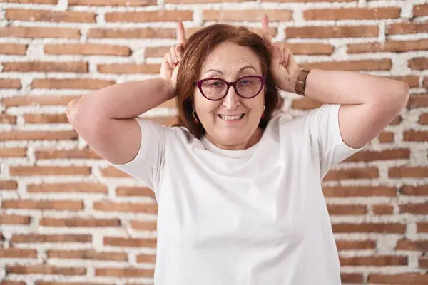 Senior Woman Glasses Standing Bricks Wall Posing Funny Crazy Fingers — Stock Photo, Image