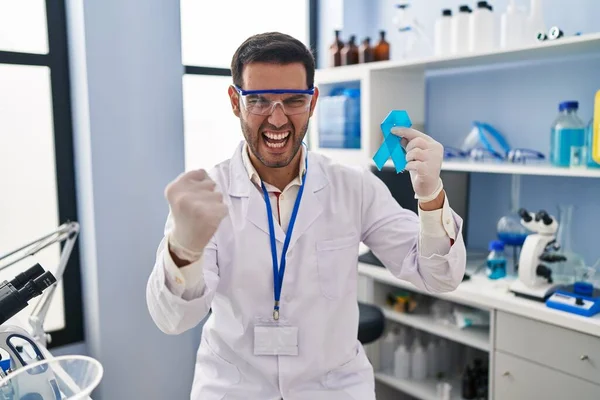 在科学家实验室工作的带着蓝带的年轻人 怒气冲冲地大喊 怒气冲冲地大喊 手举着手 气疯了 — 图库照片
