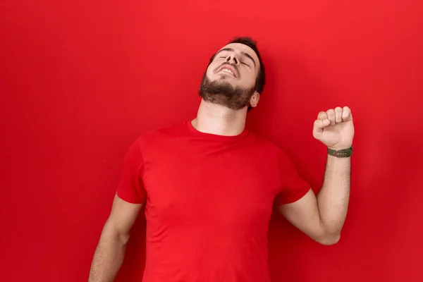 年轻的他的惊慌失措的男人穿着宽松的红色T恤 懒洋洋地伸展着 困倦着 打呵欠到一大早 — 图库照片
