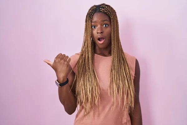Африканская Американка Плетеными Волосами Стоя Розовом Фоне Удивлен Показывая Пальцем — стоковое фото