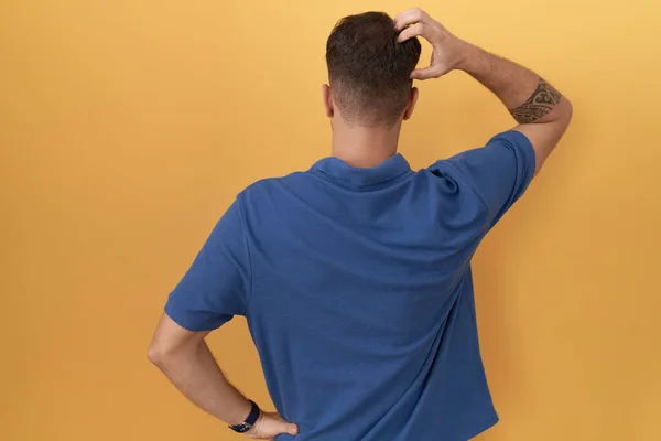 Young Hispanic Man Standing Yellow Background Backwards Thinking Doubt Hand — 스톡 사진