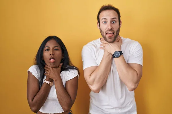 Interracial Couple Standing Yellow Background Shouting Suffocate Because Painful Strangle — Stock Photo, Image