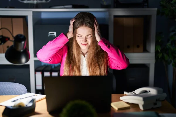 年轻的高加索女人晚上在办公室工作 由于疼痛和偏头痛 绝望和紧张 手放在头上 — 图库照片