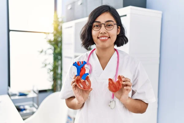 Young Latin Woman Wearing Doctor Uniform Holding Anatomical Model Heart — Stock fotografie
