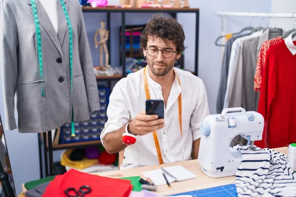 Jonge Spaanse Man Lacht Vol Vertrouwen Met Smartphone Kledingfabriek — Stockfoto