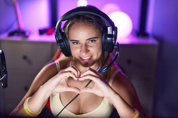 Joven Mujer Rubia Streamer Sonriendo Confiado Haciendo Símbolo Del Corazón —  Fotos de Stock