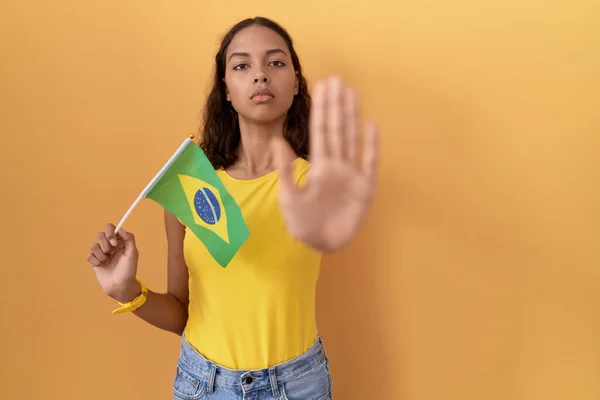Młoda Latynoska Kobieta Trzymająca Brazylijską Flagę Przestaje Śpiewać Dłonią Wyraz — Zdjęcie stockowe
