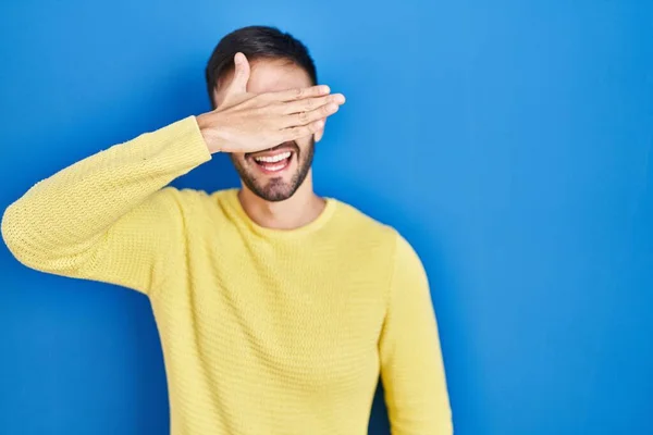 Mavi Arka Planda Dikilen Spanyol Bir Adam Gülümsüyor Gülümsüyor Gözlerini — Stok fotoğraf