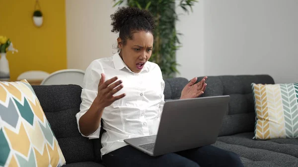 アフリカ系アメリカ人女性が家庭で不幸な表情でノートパソコンを使う — ストック写真