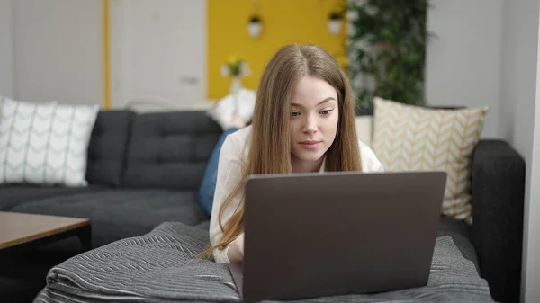 Young Blonde Woman Using Laptop Lying Sofa Home — Stockfoto