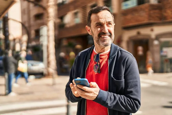 Middelbare Leeftijd Man Lacht Vol Vertrouwen Met Behulp Van Smartphone — Stockfoto