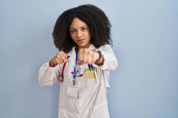 年轻的非洲裔美国妇女身穿医生制服 手持听诊器拳头进行战斗 进行咄咄逼人和愤怒的攻击 威胁和暴力 — 图库照片