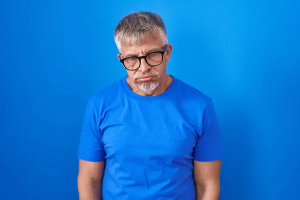 Homem Hispânico Com Cabelos Grisalhos Sobre Fundo Azul Olhando Sonolento — Fotografia de Stock