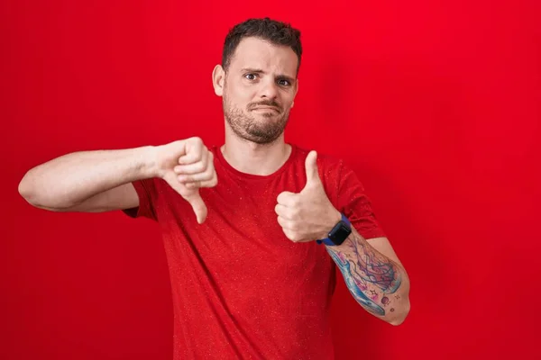 Young Hispanic Man Standing Red Background Doing Thumbs Disagreement Agreement —  Fotos de Stock
