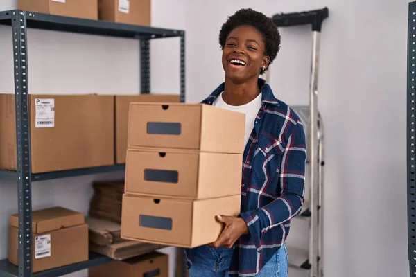 アフリカ系アメリカ人の女性が小さなビジネスのEコマースで働いている箱を持って笑って大声で笑うのは面白いクレイジー冗談だから — ストック写真