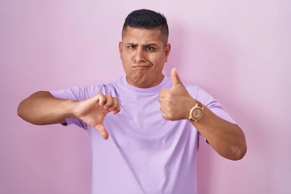 Young Hispanic Man Standing Pink Background Doing Thumbs Disagreement Agreement — Foto de Stock