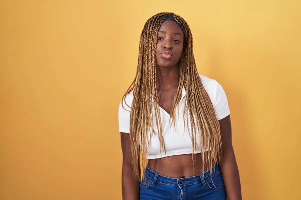 Африканская Американка Плетеными Волосами Стоящая Жёлтом Фоне Глядя Камеру Дующую — стоковое фото