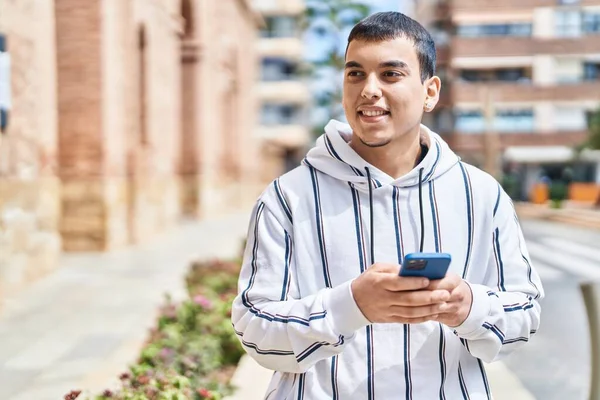 Młody Człowiek Uśmiecha Się Pewnie Pomocą Smartfona Ulicy — Zdjęcie stockowe