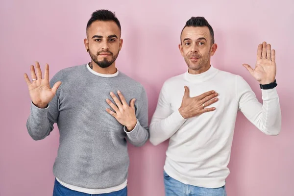 Homosexual Couple Standing Pink Background Swearing Hand Chest Open Palm — Stock Photo, Image