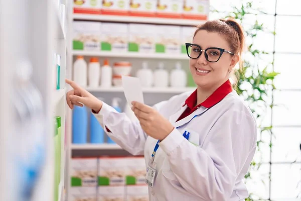 Young Beautiful Size Woman Pharmacist Smiling Confident Reading Prescription Pharmacy — Zdjęcie stockowe