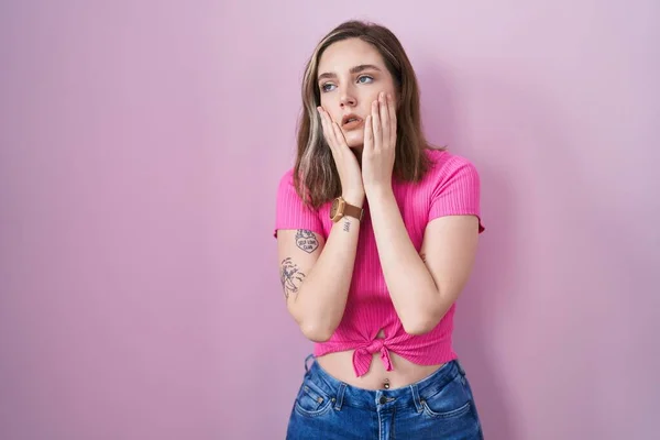 ブロンドCaucasian女性立ち上のピンクの背景疲れ手カバー顔 うつ病と悲しみ 動揺とイライラのための問題 — ストック写真