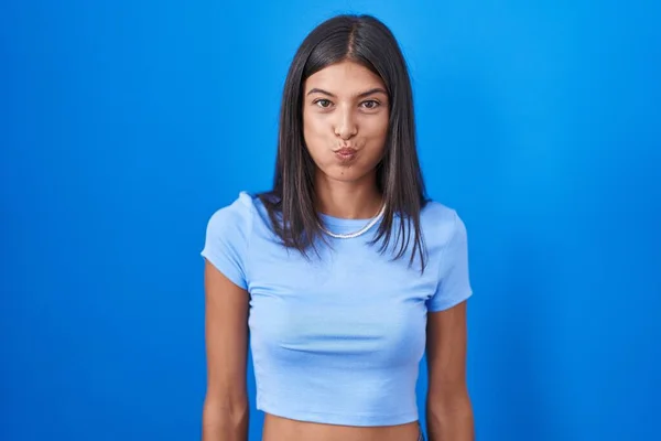 Brunette Jonge Vrouw Staat Blauwe Achtergrond Puffende Wangen Met Grappig — Stockfoto