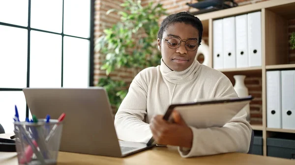 アフリカ系アメリカ人の女性ビジネスワーカーがオフィスでノートパソコン読み取り文書を使う — ストック写真