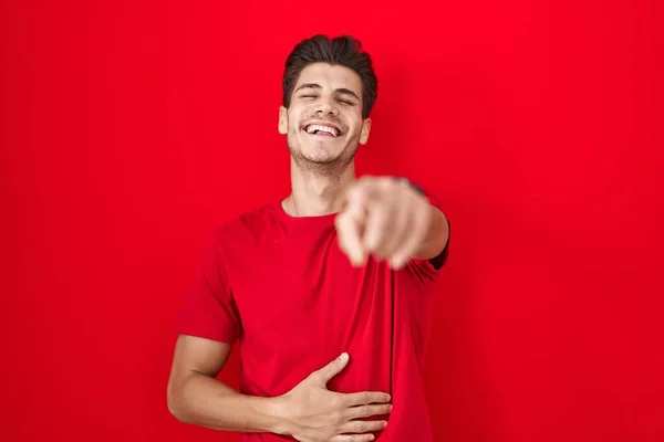 Mladý Hispánec Který Stojí Nad Červeným Pozadím Směje Ukazuje Prstem — Stock fotografie