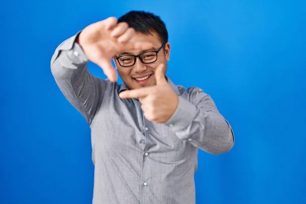 Young Chinese Man Standing Blue Background Smiling Making Frame Hands — Stock Photo, Image