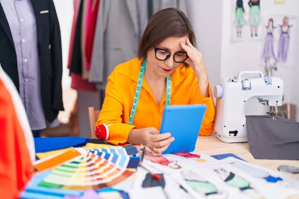 中年妇女裁缝在裁缝店使用带有严肃表情的触摸板 — 图库照片