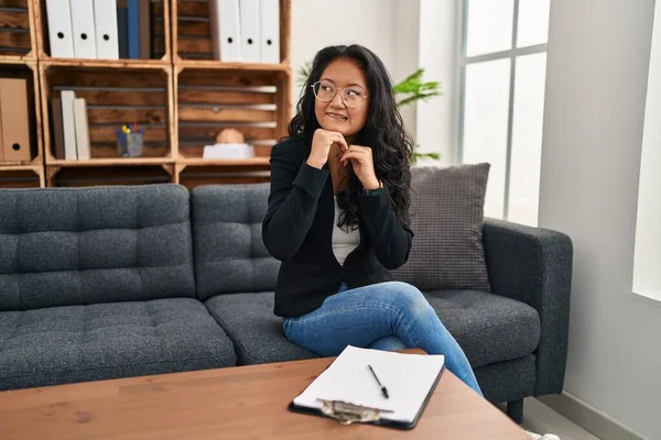 stock image Young asian woman at consultation office laughing nervous and excited with hands on chin looking to the side 