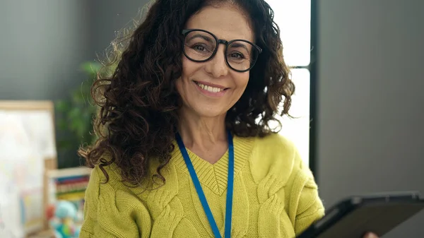 Middle Age Hispanic Woman Preschool Teacher Smiling Confident Using Touchpad — ストック写真