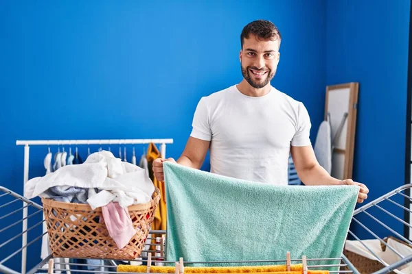 Mladý Hispánec Muž Usměvavý Sebevědomě Visí Oblečení Prádelní Šňůře Prádelně — Stock fotografie