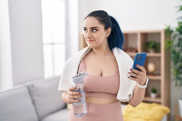 Young Caucasian Woman Smiling Confident Holding Water Using Smartphone Home —  Fotos de Stock