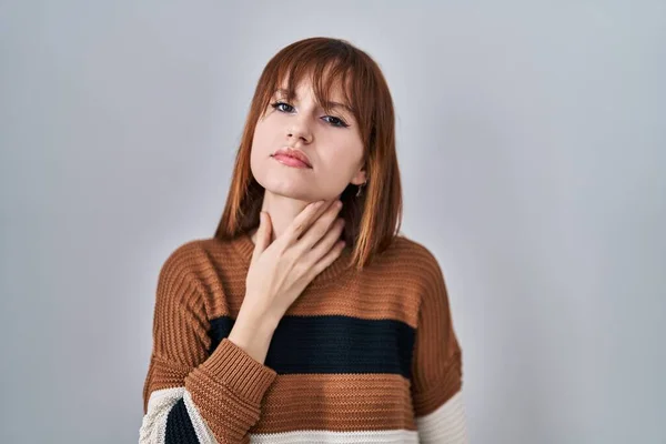 年轻美丽的女人穿着条纹毛衣 背景孤立 触痛脖子 喉头酸痛 — 图库照片