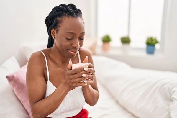 アフリカ系アメリカ人女性コーヒーを飲むカップのベッドルームでベッドに座って — ストック写真
