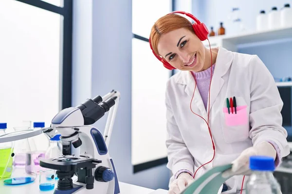 Young Caucasian Woman Scientist Listening Music Reading Notebook Laboratory — стоковое фото