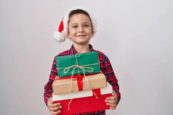 他那头戴圣诞礼帽的惊慌失措的小男孩拿着礼物庆祝胜利 睁大双眼兴奋地尖叫着 — 图库照片