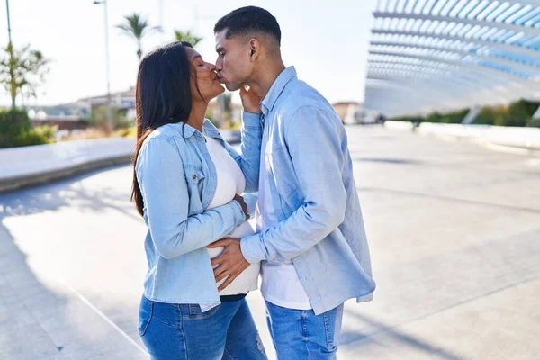 Young Latin Couple Expecting Baby Touching Belly Kissing Street — Stockfoto