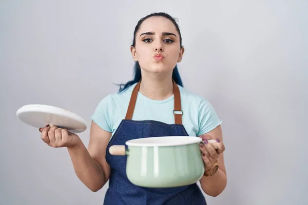 ブルーの髪をした若い現代の女の子は カメラを見て調理鍋を保持エプロンを身に着けていて キスが美しくセクシーさを吹いています 愛の表現 — ストック写真