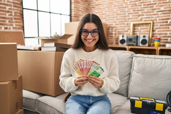 Young Hispanic Woman Sitting Sofa New Home Holding Money Smiling — Stock Photo, Image