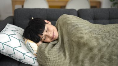 Young chinese woman lying on sofa sleeping at home