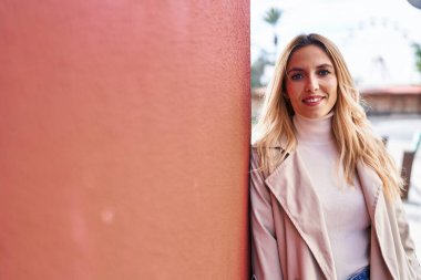 Sokakta kendine güvenen genç sarışın kadın gülümsüyor