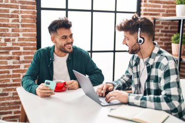 Young couple using laptop and smartphone teleworking at home