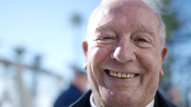 Son sınıf öğrencisi sokakta kendinden emin gülümsüyor.