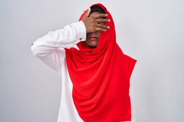 Geleneksel İslami başörtüsü takan genç bir Arap kadın gözleri kapayarak ciddi ve üzgün görünüyor. Görme, saklama ve reddetme konsepti 