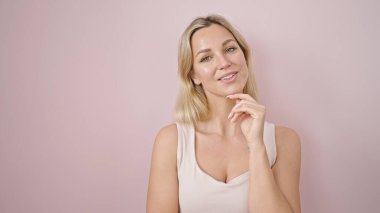 Young blonde woman smiling confident standing over isolated pink background