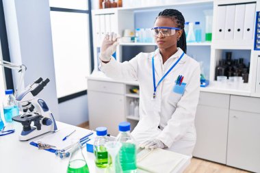 African american woman scientist holding sample at street